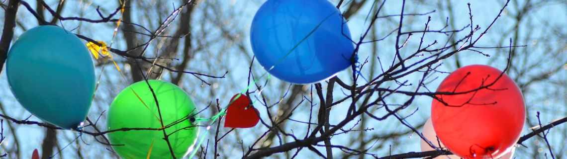 Image of helium balloons caught in a tree.